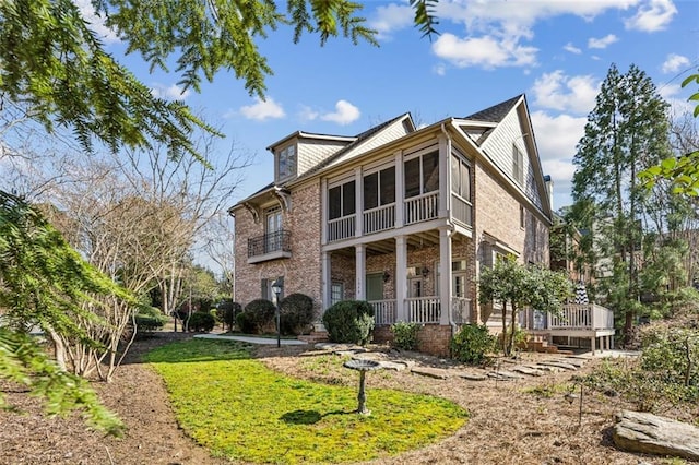 view of front of house with brick siding and a sunroom