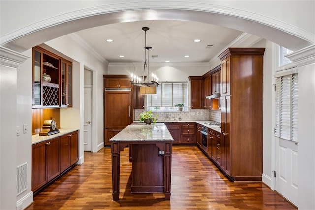 kitchen featuring arched walkways, visible vents, crown molding, and paneled fridge