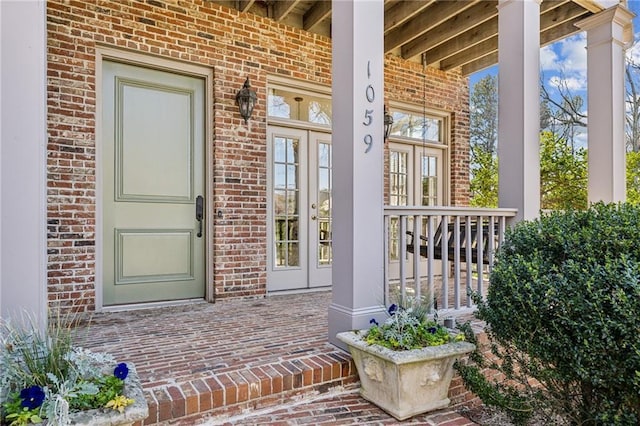 property entrance with brick siding and covered porch