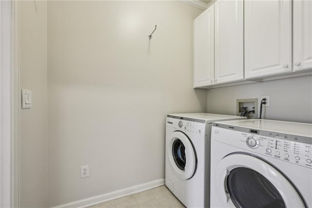 washroom featuring washer and dryer, baseboards, and cabinet space