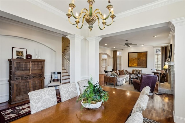 dining area featuring stairway, wood finished floors, arched walkways, and ornamental molding