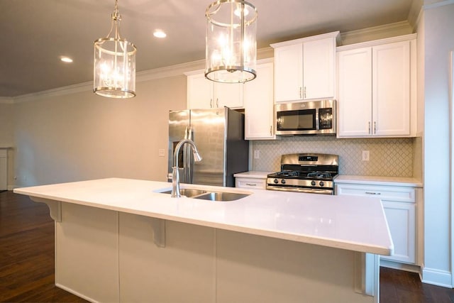 kitchen featuring ornamental molding, a center island with sink, a sink, backsplash, and stainless steel appliances