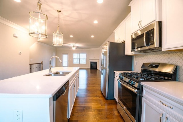 kitchen with dark wood-style floors, a sink, stainless steel appliances, white cabinets, and open floor plan