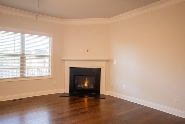 unfurnished living room featuring visible vents, baseboards, wood finished floors, and ornamental molding