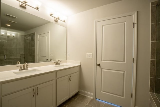 full bathroom featuring double vanity, a stall shower, visible vents, and a sink