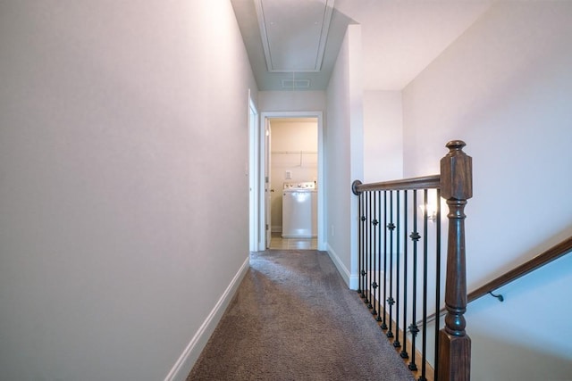 hallway featuring baseboards, visible vents, attic access, washer / dryer, and carpet flooring