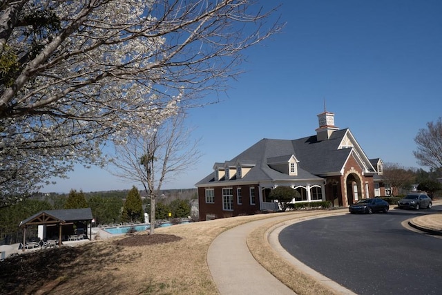 exterior space featuring an outdoor pool and curved driveway