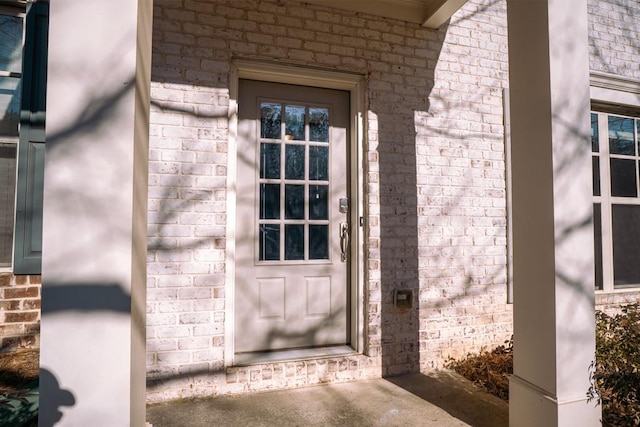 view of exterior entry featuring brick siding