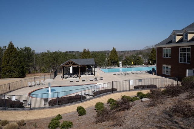 community pool featuring a gazebo, a patio area, and fence