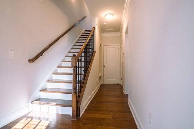 stairway featuring visible vents, crown molding, baseboards, and wood finished floors