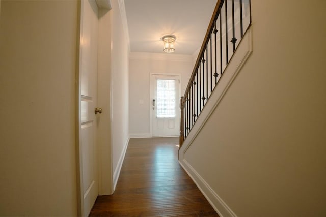 doorway to outside with dark wood finished floors, crown molding, stairway, and baseboards