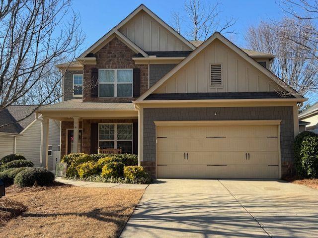 craftsman-style house featuring driveway, an attached garage, and board and batten siding