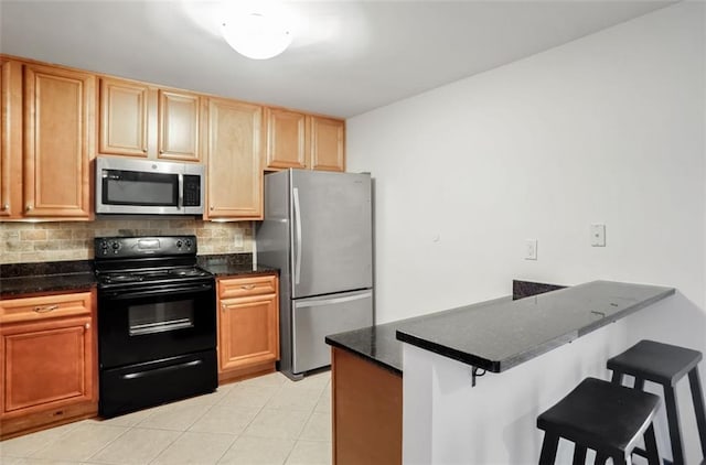 kitchen with stainless steel appliances, dark stone countertops, backsplash, kitchen peninsula, and a breakfast bar area