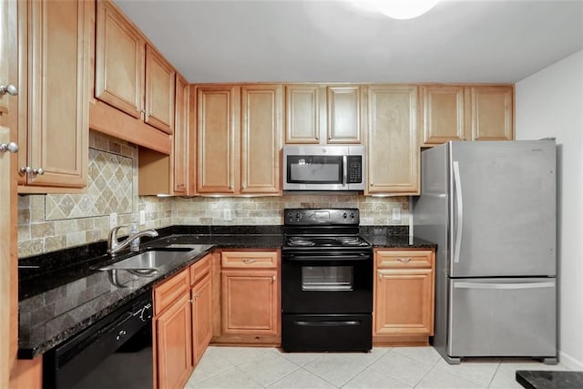 kitchen with sink, light tile patterned floors, dark stone countertops, and black appliances