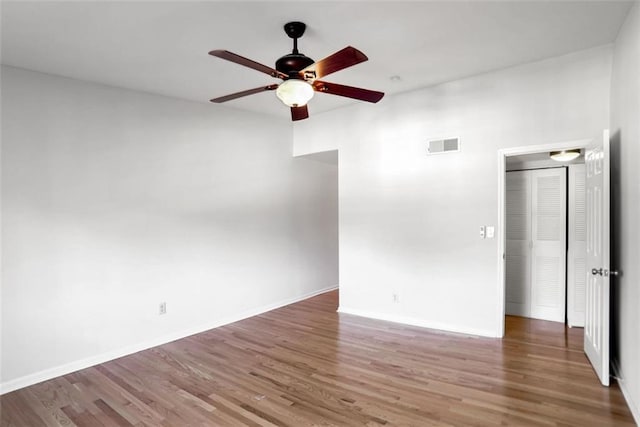 spare room with dark wood-type flooring and ceiling fan