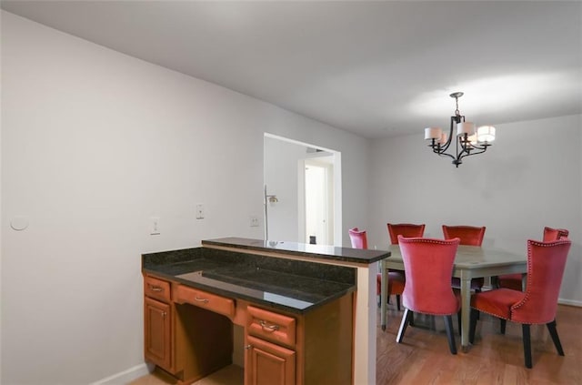 dining area with an inviting chandelier and light hardwood / wood-style flooring