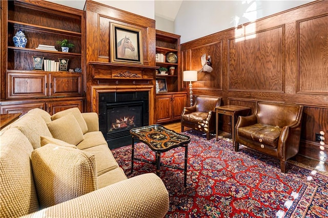 living area with built in features and vaulted ceiling