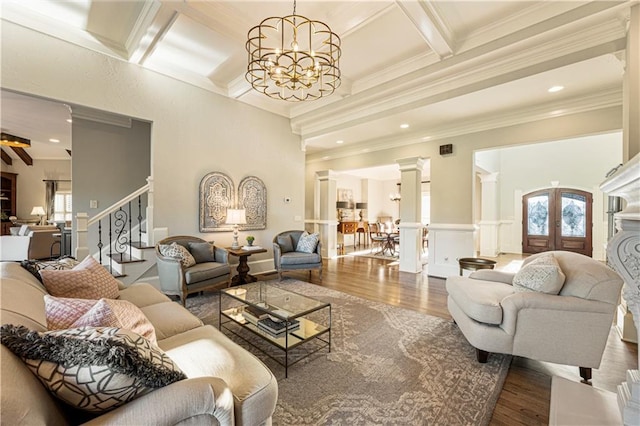 living room featuring a wealth of natural light, dark wood-type flooring, coffered ceiling, and a notable chandelier