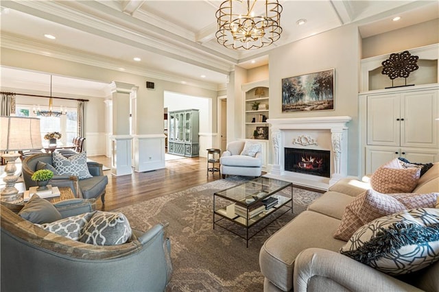 living room with built in features, beamed ceiling, a chandelier, wood-type flooring, and a fireplace