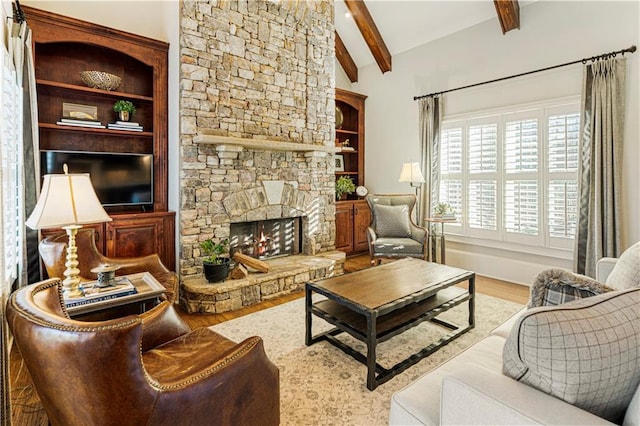 living room featuring a stone fireplace, hardwood / wood-style floors, and vaulted ceiling with beams