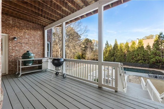 deck with grilling area and a covered pool