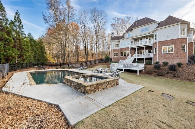 view of pool with a wooden deck, an in ground hot tub, and a yard