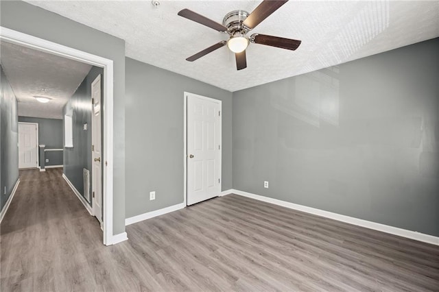 3303 Par Three Way, Lithonia, GA 30038 - unfurnished bedroom featuring a textured ceiling, wood finished floors, and a ceiling fan