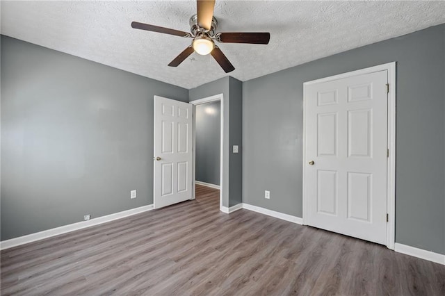 3303 Par Three Way, Lithonia, GA 30038 - unfurnished bedroom with a textured ceiling, wood finished floors, and a ceiling fan