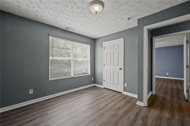 3303 Par Three Way, Lithonia, GA 30038 - unfurnished bedroom featuring dark wood-style floors and a textured ceiling