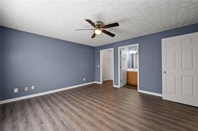 3303 Par Three Way, Lithonia, GA 30038 - unfurnished bedroom featuring wood finished floors, a textured ceiling, a closet, a walk in closet, and a ceiling fan