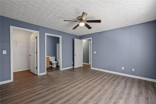 3303 Par Three Way, Lithonia, GA 30038 - unfurnished bedroom with wood finished floors, a closet, a spacious closet, a textured ceiling, and ensuite bath