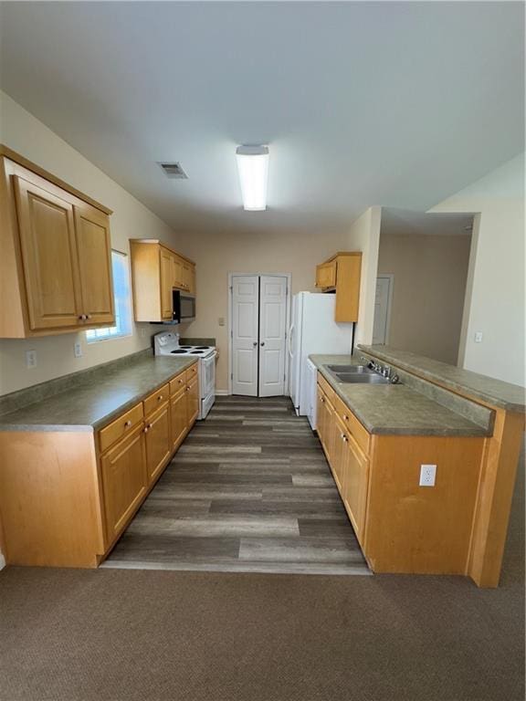 118 Pointe Cir, Dahlonega, GA 30533 - kitchen featuring white appliances, dark countertops, dark wood finished floors, and a peninsula