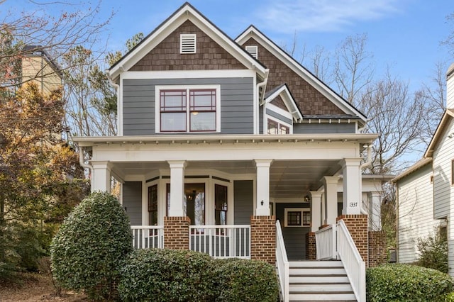 craftsman-style home featuring a porch and brick siding