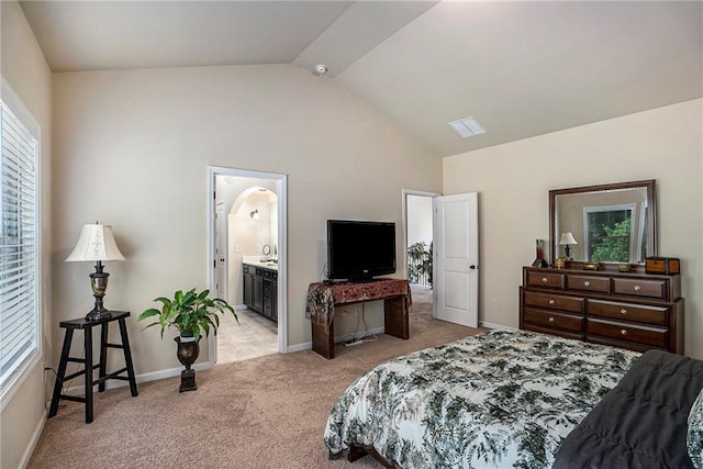 carpeted bedroom featuring lofted ceiling and connected bathroom