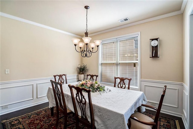 dining room with ornamental molding, a chandelier, and dark hardwood / wood-style flooring