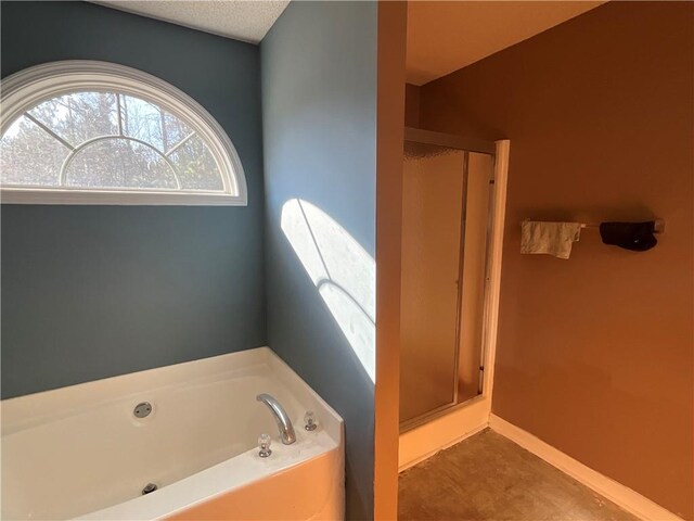 bathroom with a textured ceiling and independent shower and bath