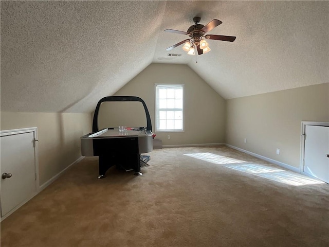 bonus room featuring a textured ceiling, ceiling fan, carpet, and lofted ceiling