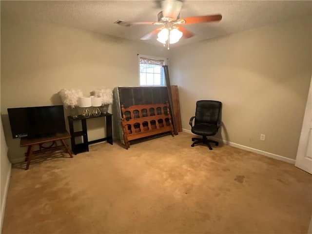 living area featuring ceiling fan and carpet