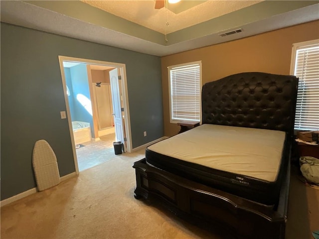 bedroom with ensuite bathroom, ceiling fan, and light colored carpet