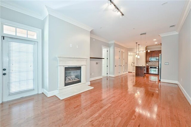 unfurnished living room featuring crown molding and light hardwood / wood-style flooring