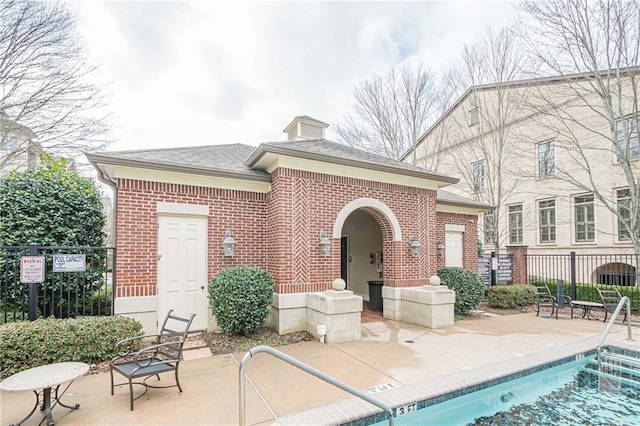 back of house featuring a community pool and a patio area