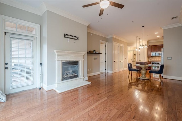 living room with crown molding, ceiling fan, and light hardwood / wood-style flooring