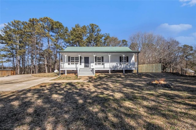 view of front of property featuring metal roof, a porch, crawl space, and fence