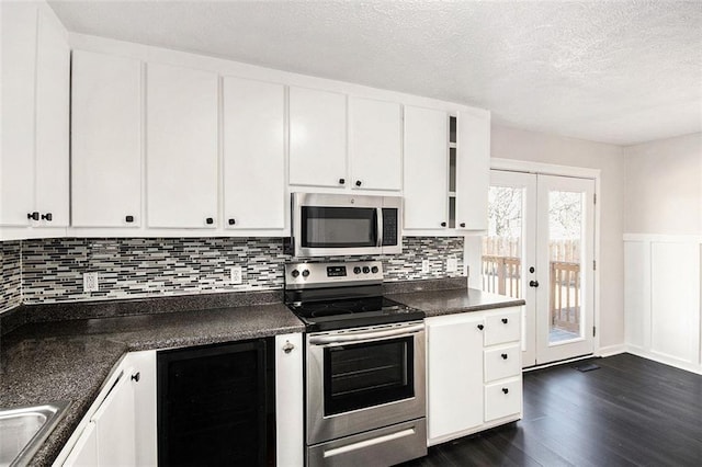 kitchen featuring dark countertops, dark wood-style floors, beverage cooler, and appliances with stainless steel finishes