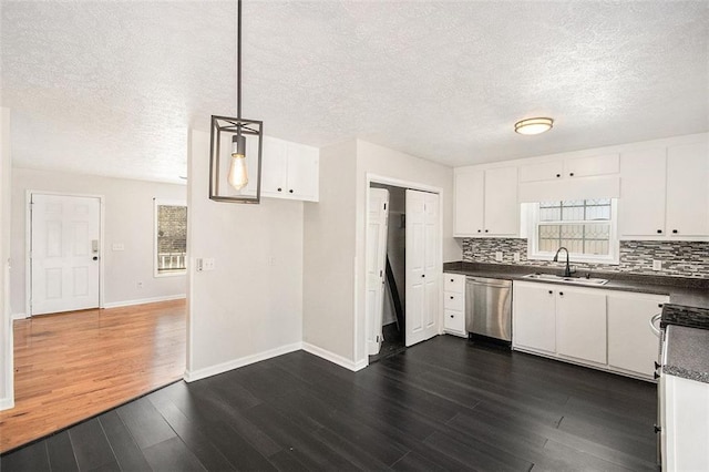 kitchen featuring a sink, dark countertops, tasteful backsplash, and dishwasher