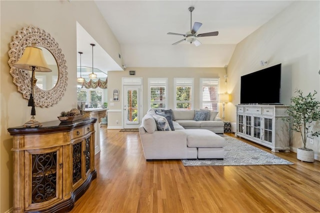 living area featuring a ceiling fan, lofted ceiling, plenty of natural light, and light wood finished floors