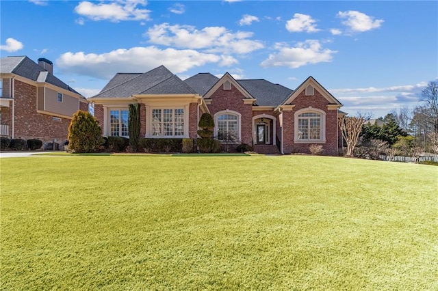 view of front facade featuring brick siding and a front yard