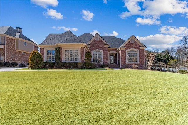 view of front of home featuring brick siding and a front lawn