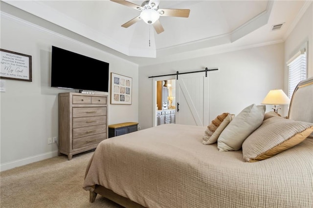 bedroom with light carpet, a tray ceiling, a barn door, and crown molding