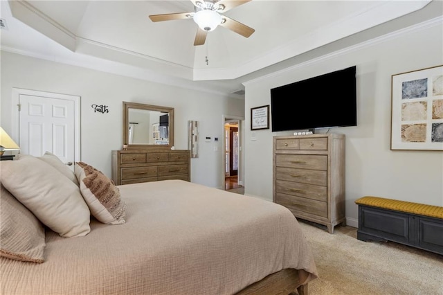 bedroom with a raised ceiling, crown molding, and light colored carpet